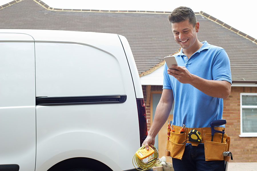 Contact - Happy Electrician Next To Van Using Phone