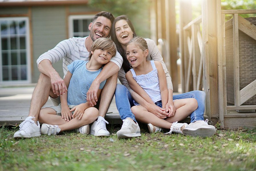 Personal Insurance - Happy Family Sitting In Backyard